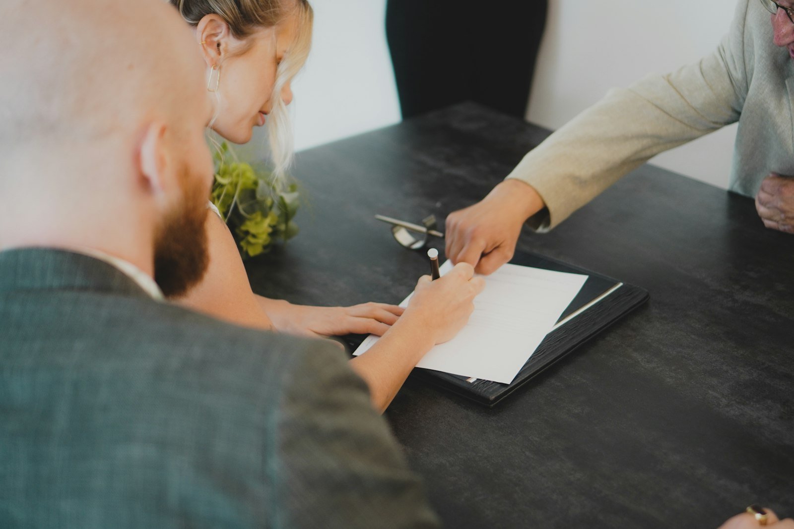 Buyers and agent signing a property contract after negotiating the price