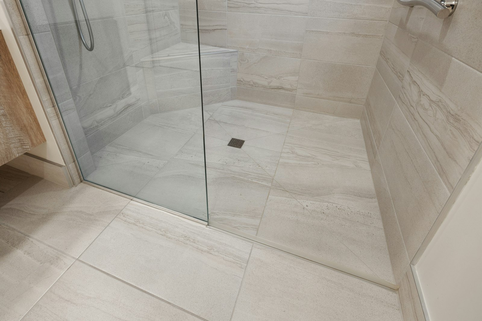 Tiled walk-in shower floor with drain, where waterproofing commonly fails